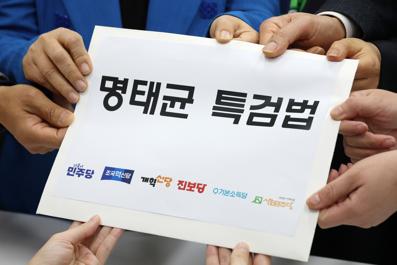 Lawmakers of the opposition bloc hold up a paper that says "Myung Tae-kyun special counsel bill," as they propose a special counsel bill on allegations surrounding self-proclaimed political broker Myung Tae-kyun at the National Assembly on Feb. 11. (Im Se-jun/The Korea Herald)