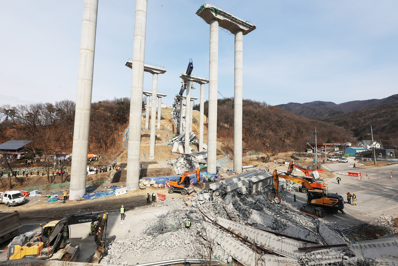 25일 경기도 안성시 서운면 산평리 소재 서울세종고속도로 천안~안성구간 9공구 천용천교 건설 현장에서 교량 연결작업 중 교각에 올려놓았던 상판이 무너지는 사고가 발생해 소방대원들이 인명 수색 구조작업을 하고 있다. [연합]