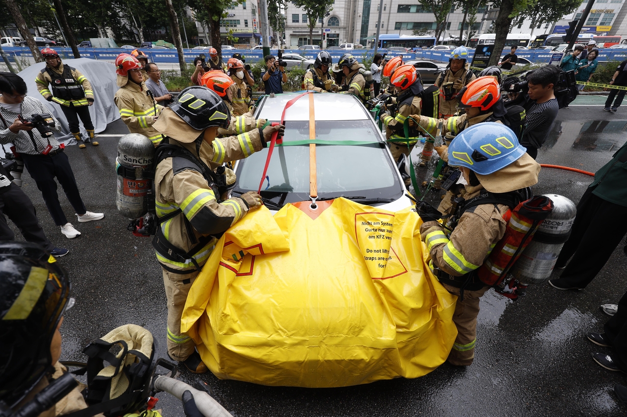 Firefighting officials practice during a joint fire drill held to respond to EV fires at a public parking lot near Maeheon Citizen’s Forest in Seocho-gu, southern Seoul, on Sept. 2, 2024. (Im Se-jun/The Korea Herald)