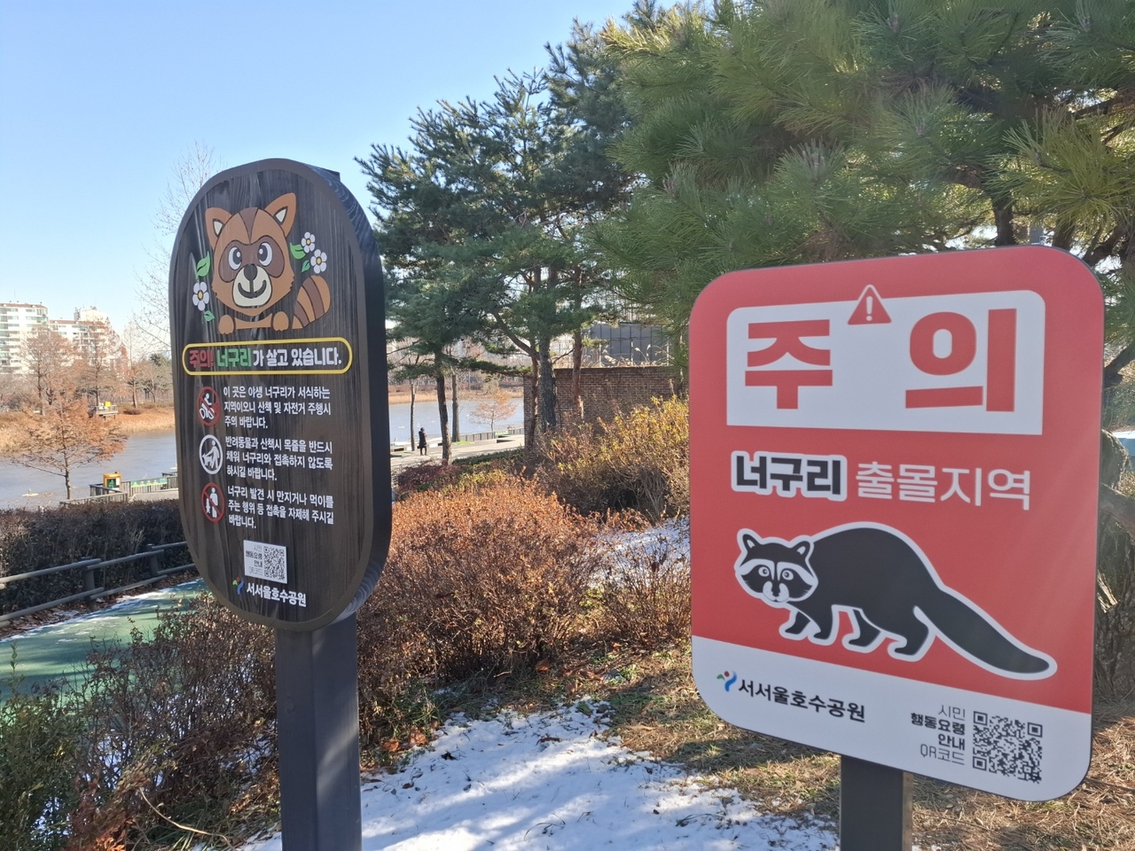 Caution signs for raccoon dog sightings at the West Seoul Lake Park (Shin Ji-hye/The Korea Herald)