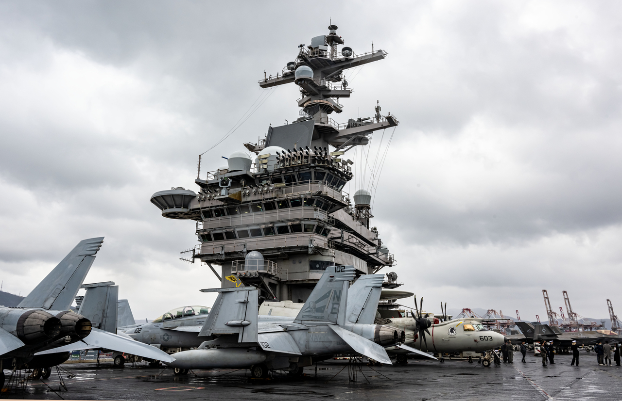Aircraft and crew members line the deck of the US Navy's nuclear-powered aircraft carrier USS Carl Vinson, which is docked at a South Korean military base in Busan on Monday, along with other warships of Carrier Strike Group 1.  (Joint Press Corps)