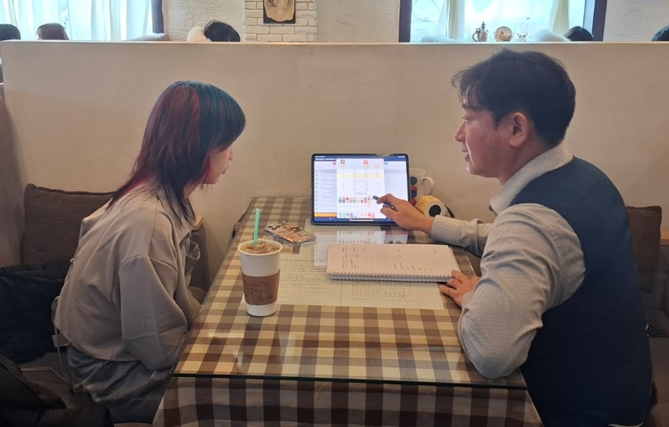 American visitor Joy Bunch listening to a Korean saju fortune teller during a reading at a saju cafe in Hongdae, Seoul