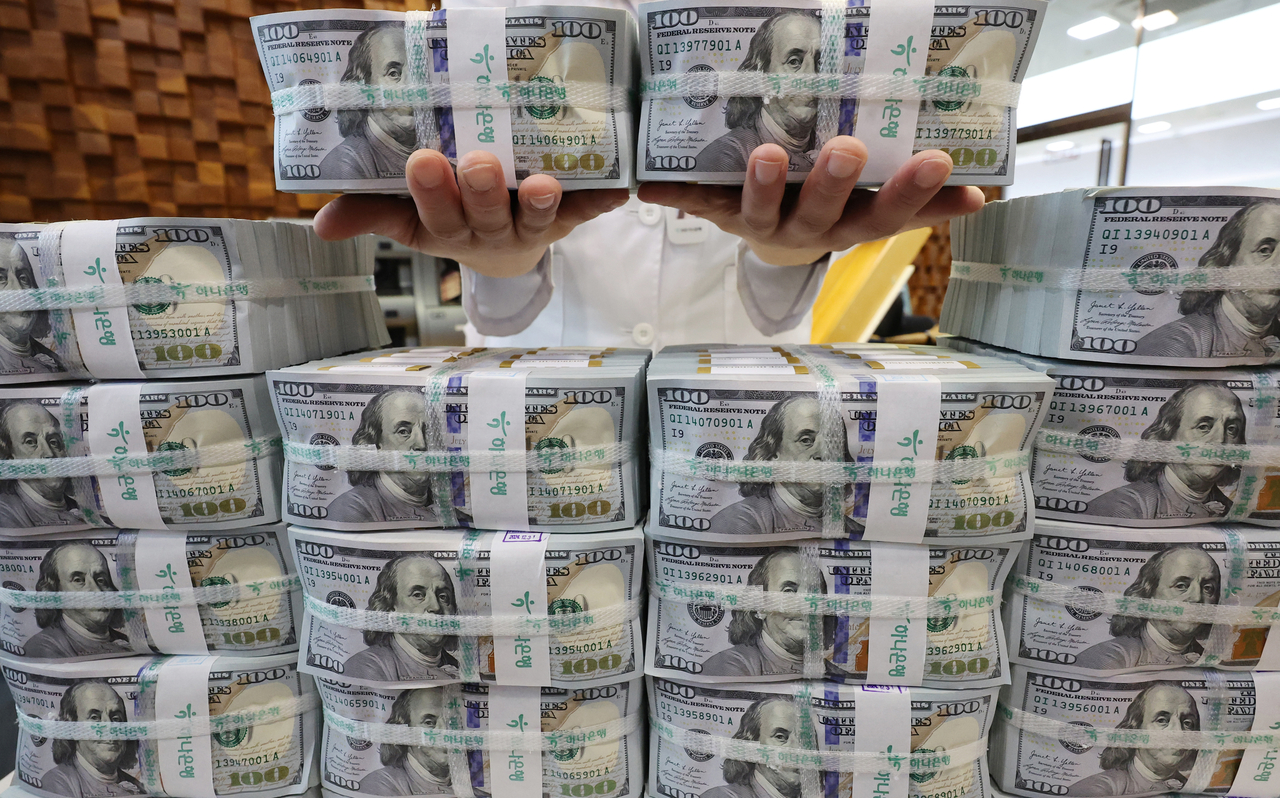 An official checks banknotes at a Hana Bank branch in Seoul on Feb. 18. (Yonhap)