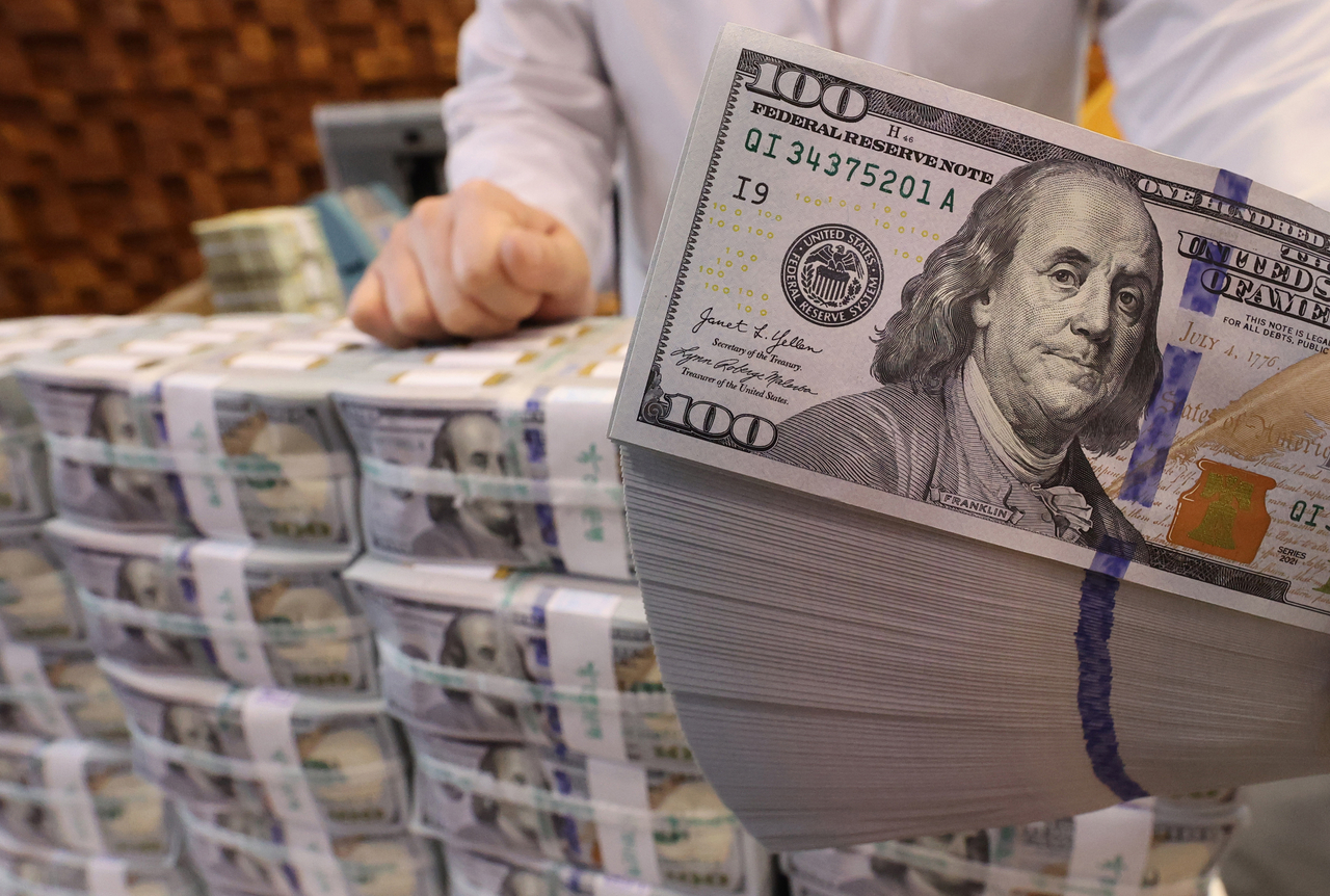In this file photo, an official checks dollar notes at Hana Bank's Counterfeit Notes Response Center in Seoul on Feb. 18. (Yonhap)