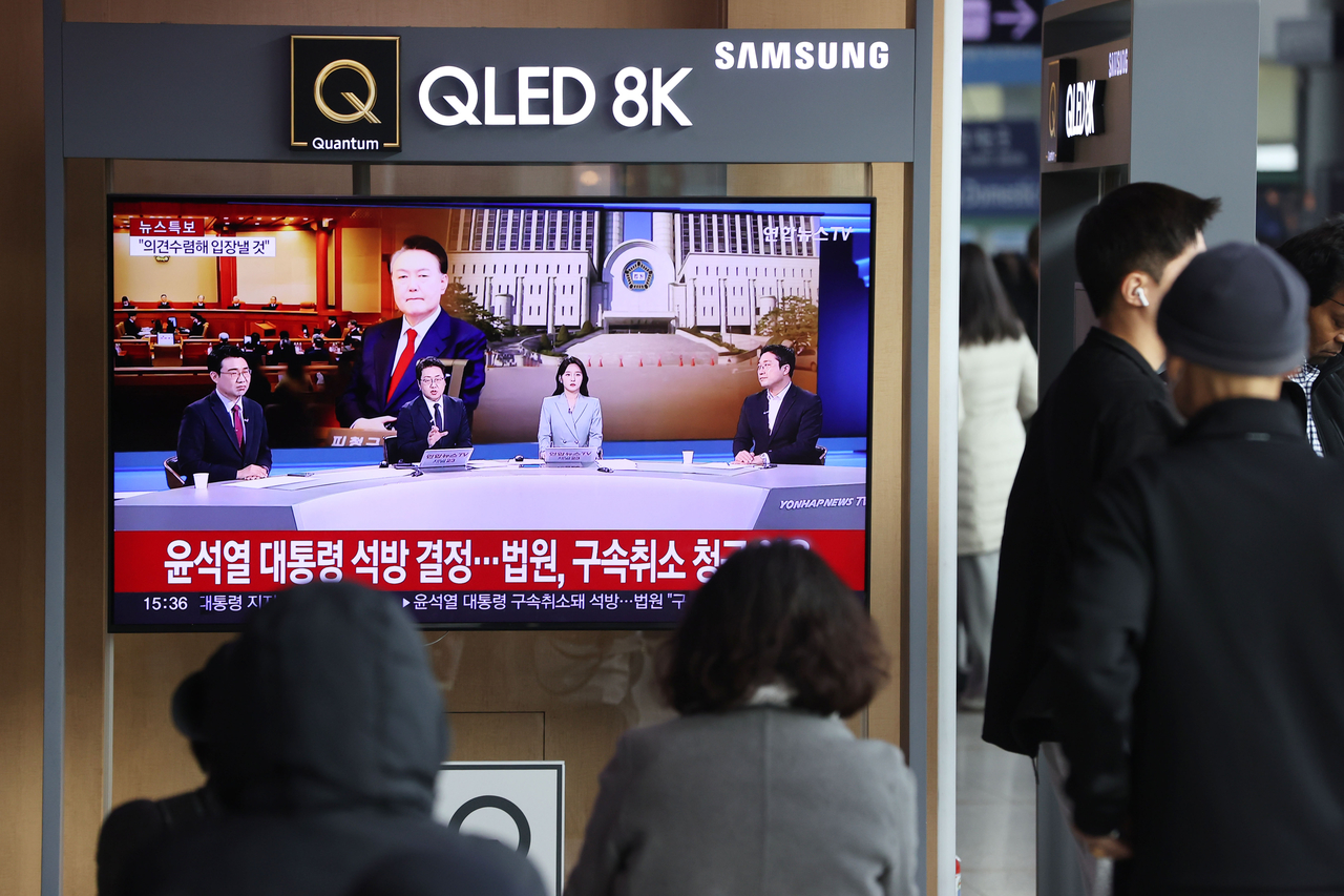 법원이 윤석열 대통령이 낸 구속 취소 청구를 받아 들인 지난 7일 서울역 대합실에서 시민들이 윤 대통령 관련 뉴스를 시청하고 있다. [연합]