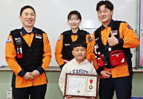 Jeong Tae-un poses with officials from Bucheon Fire Station after being commended for performing CPR that helped save his mother. (Courtesy of the Bucheon Fire Station)
