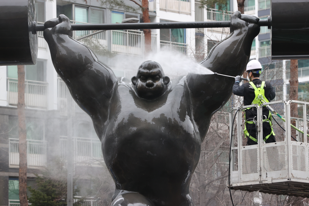A worker from Sogpa-gu Office uses a high-pressure washer to clean a statue, one of 51 commemorating the 1988 Seoul Olympics near Jamsil Sports Complex in Seoul on Wednesday. (Yonhap)