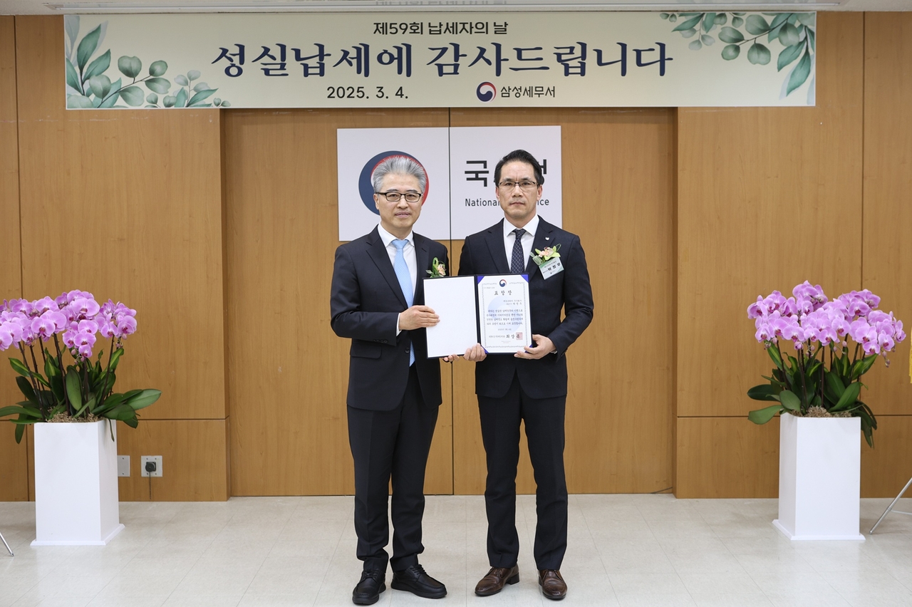 캐논코리아가 ‘납세자의 날’ 모범납세자 표창을 수상했다. 사진은 최영철(왼쪽) 삼성세무서장과 김정식 캐논코리아 재경부문장이 기념 촬영을 하는 모습. [캐논코리아 제공]