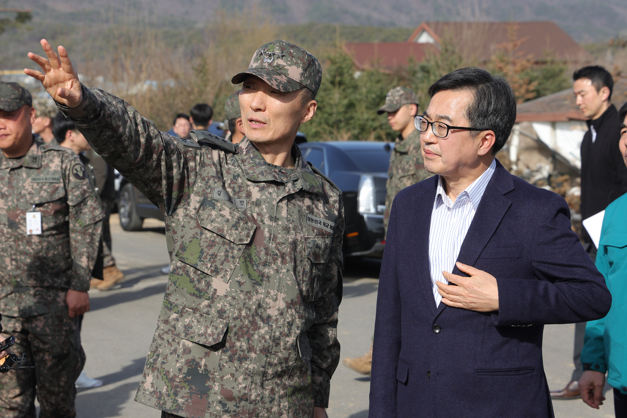 김동연 경기도지사(오른쪽)가 13일 오후 경기도 포천시 이동면 노곡리 공군 전투기 오폭 사고 현장에서 김성민 5군단장과 함께 현장 복구 상황을 살펴 보고 있다. [연합]