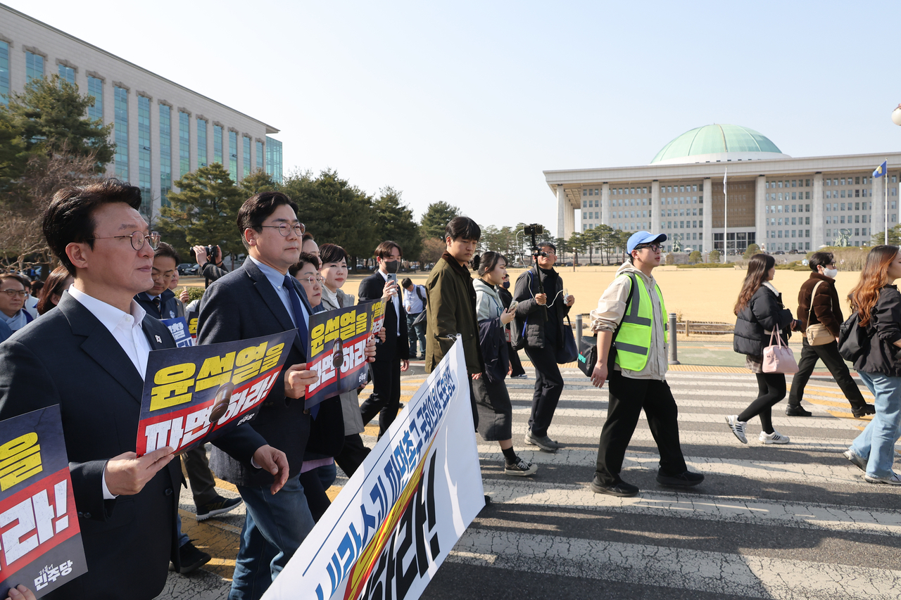 Democratic Party of Korea lawmakers begin a march calling for the Constitutional Court to uphold President Yoon Suk Yeol's impeachment at the National Assembly compound on Friday. Yonhap