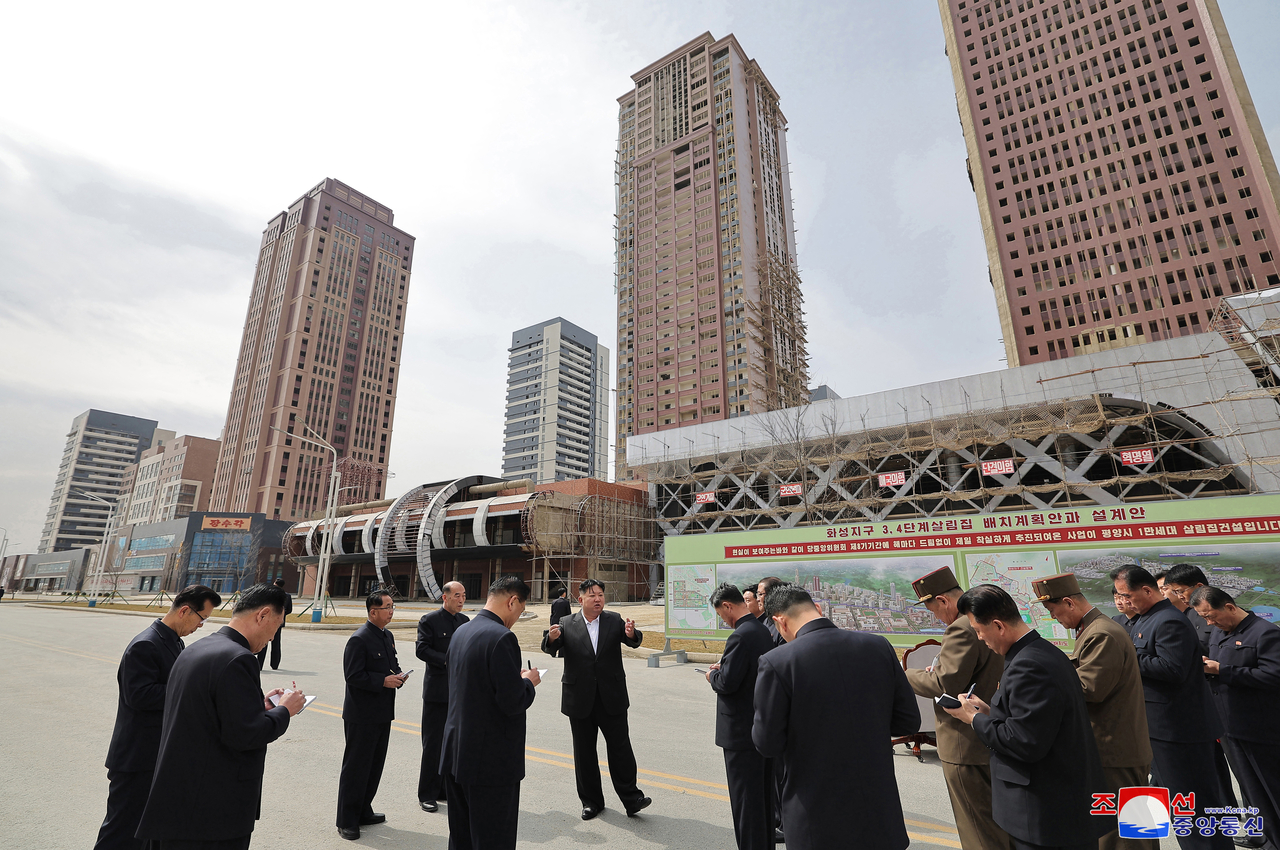 North Korean leader Kim instructs officials during his inspection of the Hwasong Street apartment construction project on Saturday. (KCNA via Yonhap)