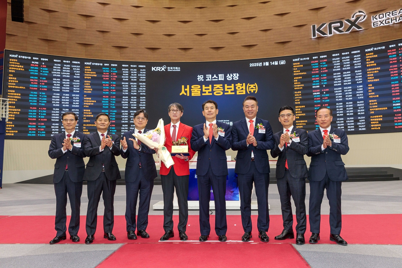 Seoul Guarantee Insurance President and CEO Lee Myung-soon (fourth from left) poses for photo during the listing ceremony at the Korea Exchange on Friday. (Seoul Guarantee Insurance)