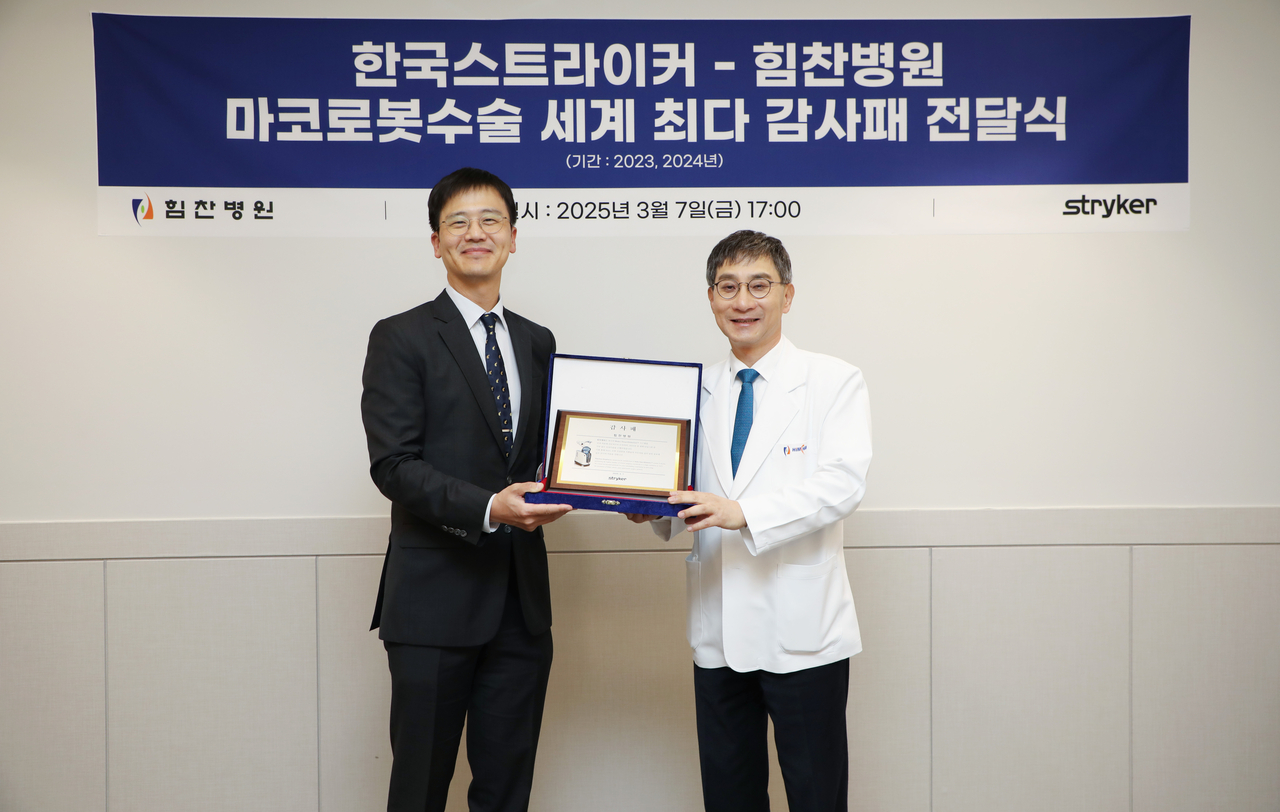 Dr. Lee Soo-chan (right), representative director of Himchan Hospital, and Stryker Korea CEO Shim Hyun-woo pose for a photo during an appreciation plaque awarding ceremony at the Seoul hospital earlier this month. (Himchan Hospital)
