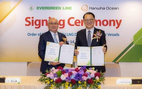 This photo, provided on Monday, shows a recent contract signing ceremony between the South Korean shipyard and Evergreen Marine Corp. of Taiwan, attended by Hanwha Ocean CEO Kim Hee-cheul and Evergreen Marine Chairman Chang Yen-I. (Hanwha Ocean Co.)