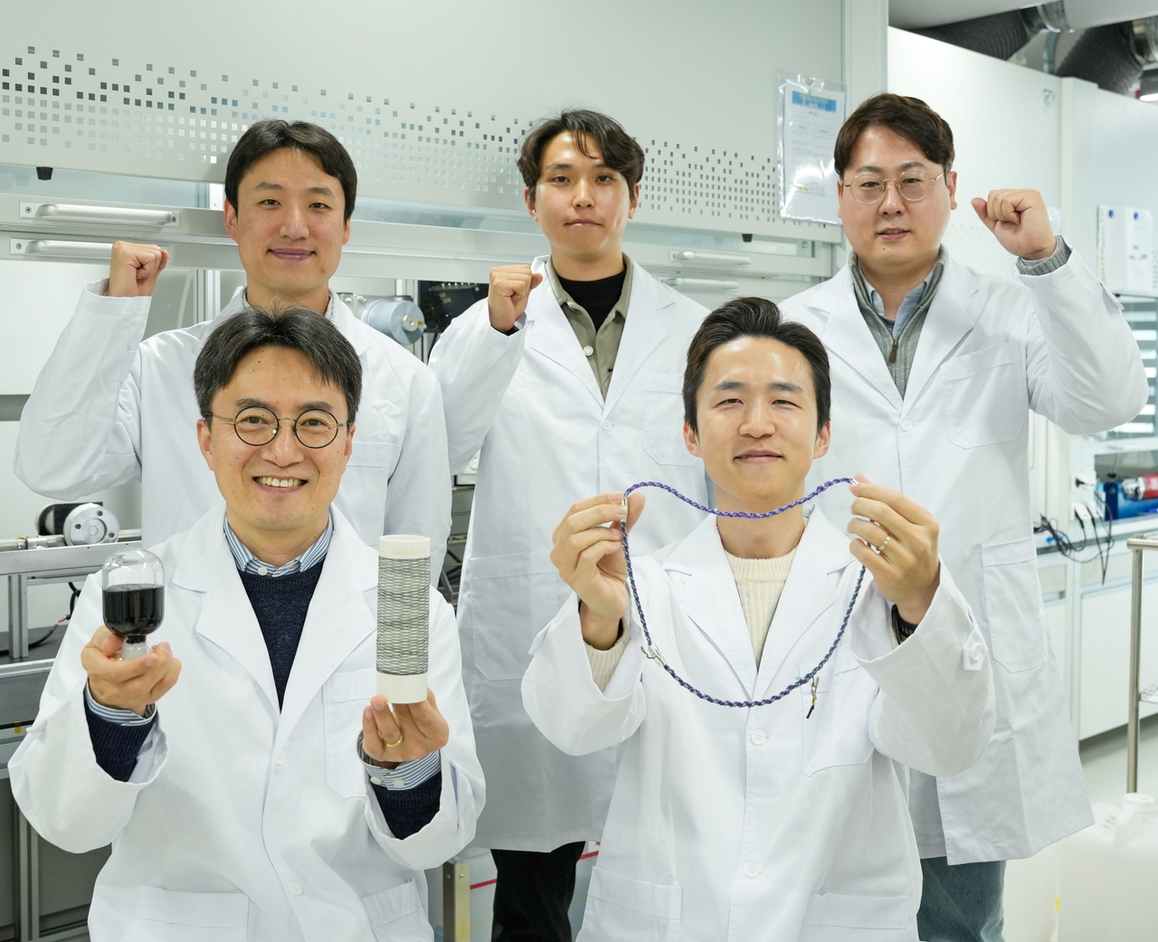한중탁(앞줄 왼쪽) 박사 연구팀이 각각 CNT 용액 및 와이어, 목걸이형 슈퍼커패시터를 들고 포즈를 취하고 있다.