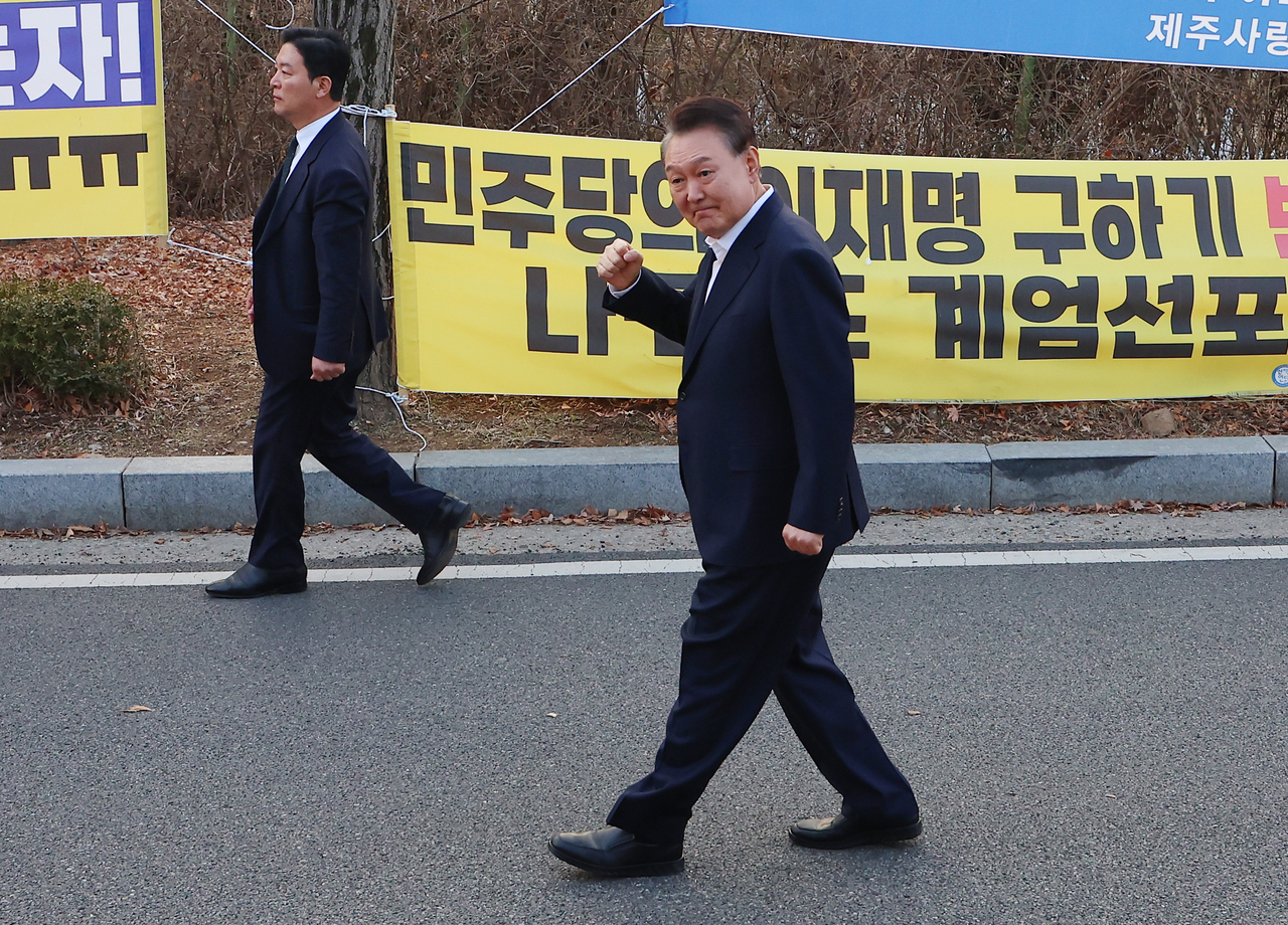 석방된 윤석열 대통령이 8일 경기도 의왕시 서울구치소 앞에서 경호차량에서 내려 지지자들에게 인사하고 있다. 그 옆으로는 김성훈 경호처 차장이 윤 대통령을 경호하며 이동하고 있다. [연합]