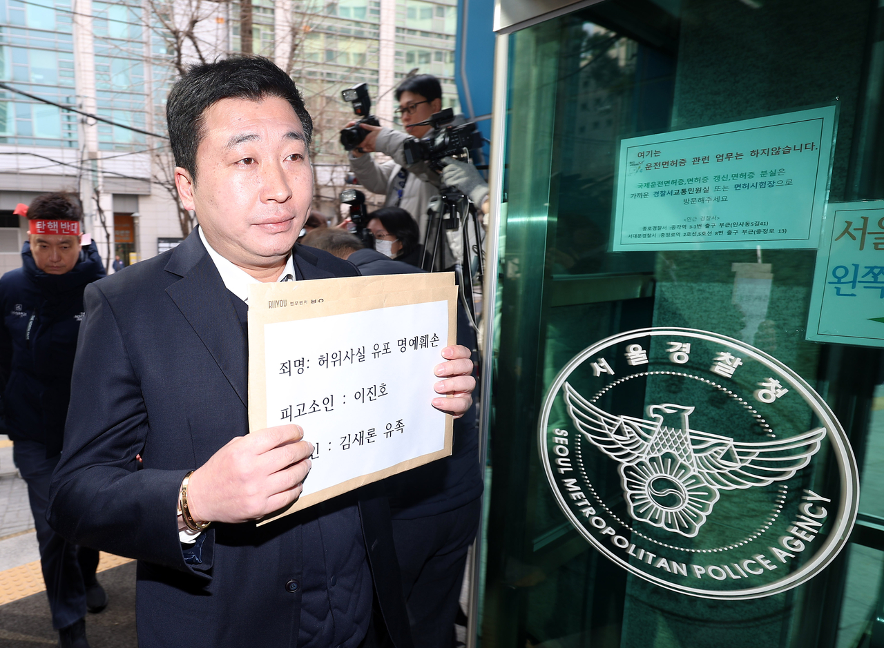 Attorney Bu Ji-seok holds up a complaint filed by the bereaved family of Kim Sae-ron upon entering the Seoul Metropolitan Police Agency on Monday. (Newsis)