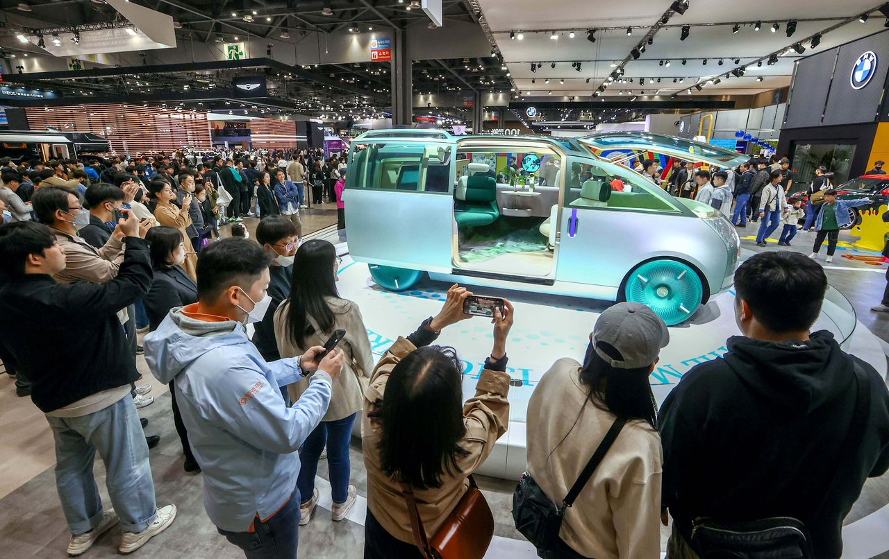 Visitors take photos of a vehicle on display at the Seoul Mobility Show at Kintex in Goyang, Gyeonggi Province, in April 2023. (Seoul Mobility Show)