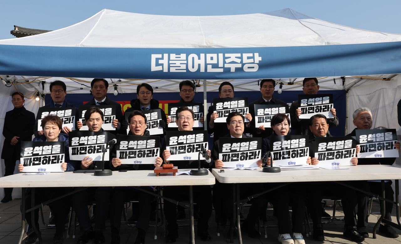더불어민주당 이재명 대표와 박찬대 원내대표가 19일 서울 종로구 경복궁역 부근 광화문 민주당 천막농성장에서 열린 현장 최고위원회의에서 “윤석열을 파면하라!”라고 적힌 피켓을 들고 구호를 외치고 있다. 국회사진기자단