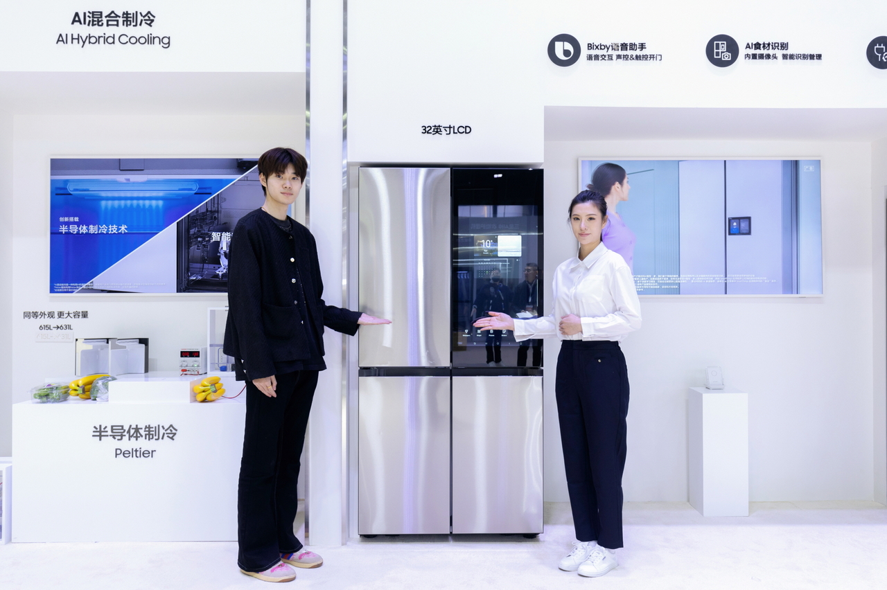 Models pose with Samsung Electronics' Bespoke refrigerator with AI family hub. (Samsung Electronics)