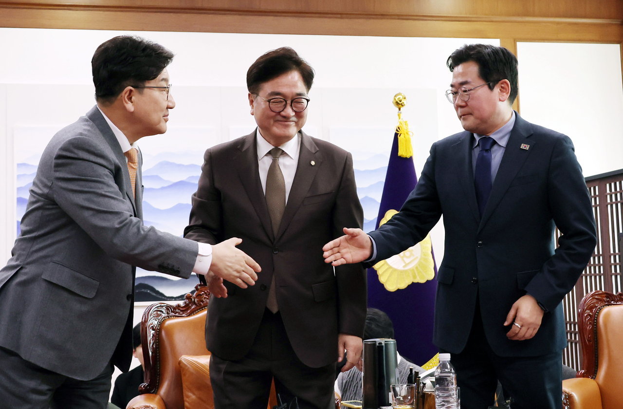 Ruling People Power Party Floor Leader Rep. Kweon Seong-dong (left) moves to shake hands with main opposition Democratic Party of Korea Floor Leader Rep. Park Chan-dae (right) in their meeting with National Assembly Speaker Rep. Woo Won-shik (second from left) as the major parties reached a compromise over the pension reform plan at the National Assembly in Seoul on Thursday. (Yonhap)