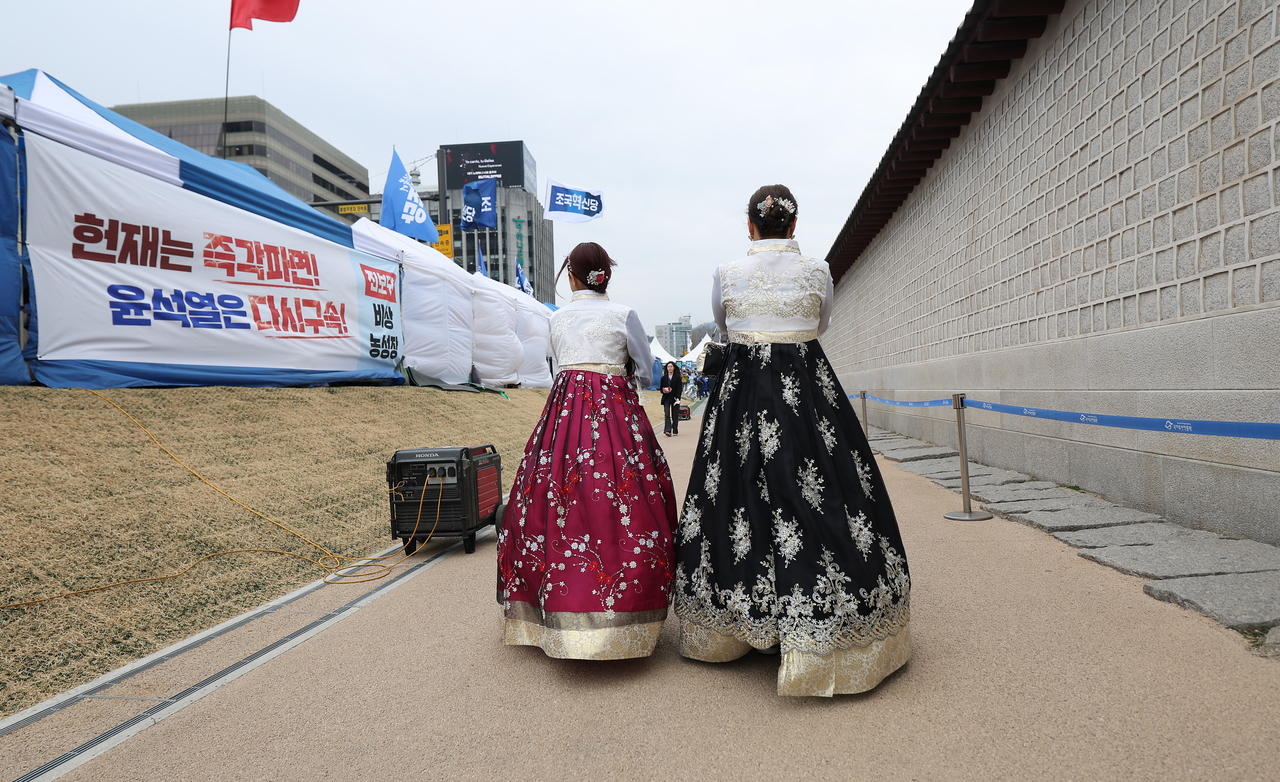Foreign tourists walk outside the Gyeongbokgung in Jung-gu, Seoul, March 12. (Yohap)