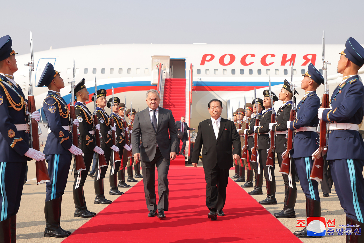 Russian Security Council Secretary Sergei Shoigu (left) walks on a red carpet with Pak Jong-chon, vice-chair of the Central Military Commission of the Workers’ Party of Korea, at Pyongyang International Airport on Friday, in this photo provided by the Korean Central News Agency. (Yonhap)