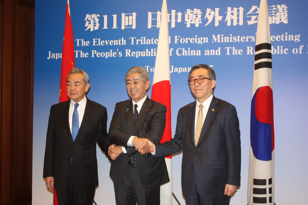 Foreign Minister Cho Tae-yul (right) poses for a photo with Japanese Foreign Minister Takeshi Iwaya (center) and Chinese Foreign Minister Wang Yi on Friday as they arrived for a dinner reception at a hotel in Tokyo, where the three ministers have gathered for trilateral talks. (Yonhap)