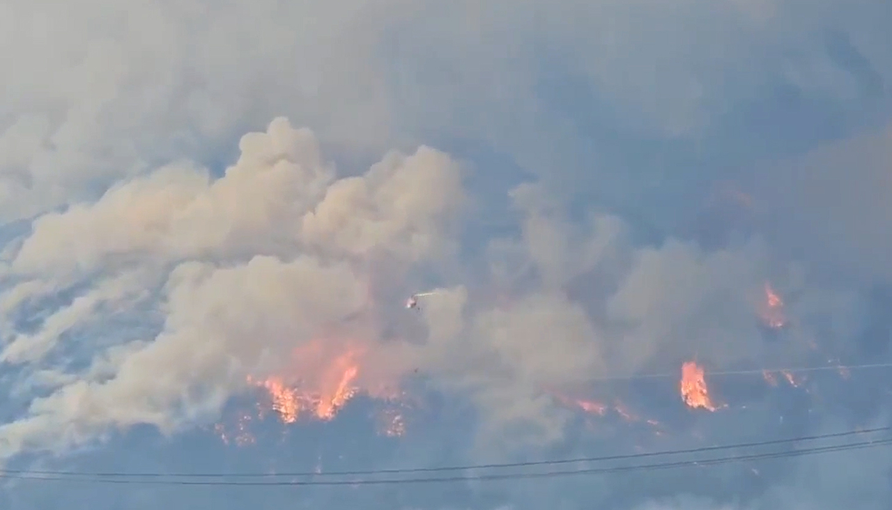 Smoke rises from wildfires burning in Sancheong County, South Gyeongsang Province, for a second day on Saturday, prompting evacuations in nearby villages. (Yonhap)