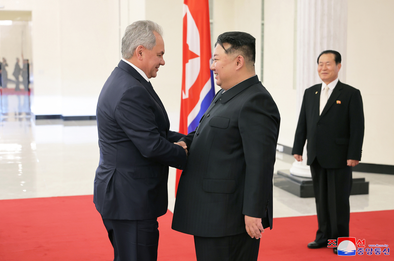 This photo, carried by North Korea's official Korean Central News Agency on March 22, 2025, shows the North's leader Kim Jong-un (right) shaking hands with Sergei Shoigu, secretary of Russia's Security Council, in Pyongyang the previous day. (Yonhap)