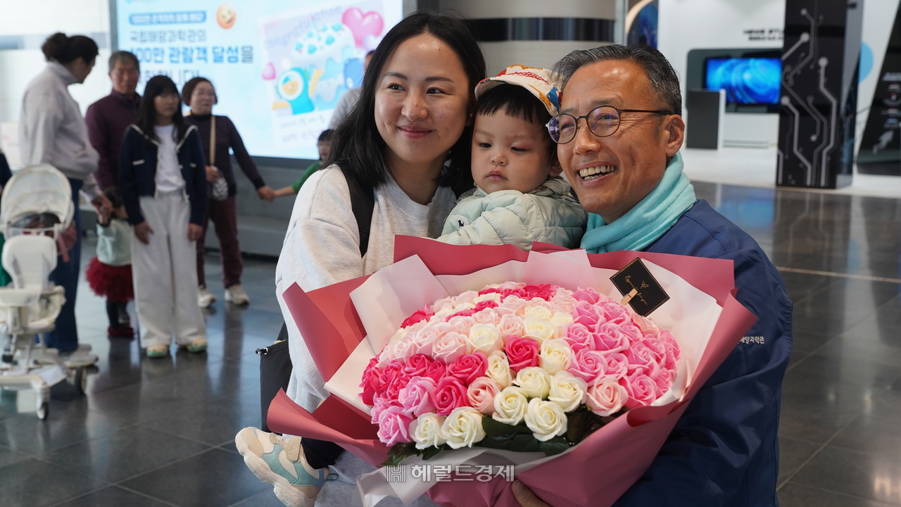 김외철(오른쪽) 국립해양과학관 관장이  누적관람객 100만번 째인 박수민씨 가족과 기념촬영을 하고 있다. (국립해양과학관 제공)