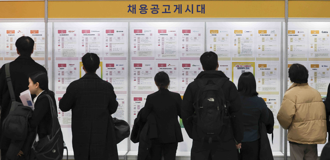 Job seekers review postings at a recruitment board during the 2025 Korea Job Fair, held Wednesday at the aT Center in Seoul's Seocho District. (Newsis)