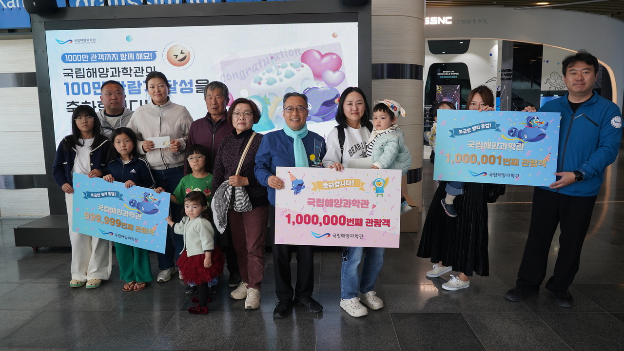 김외철(앞줄 가운데) 국립해양과학관 관장이 지난 22일 누적관람객 100만번 째인 박수민씨 가족과  99만9999번째 및 1001만 관람객 등과 함께 기념촬영을 하고 있다. (국립해양과학관 제공)