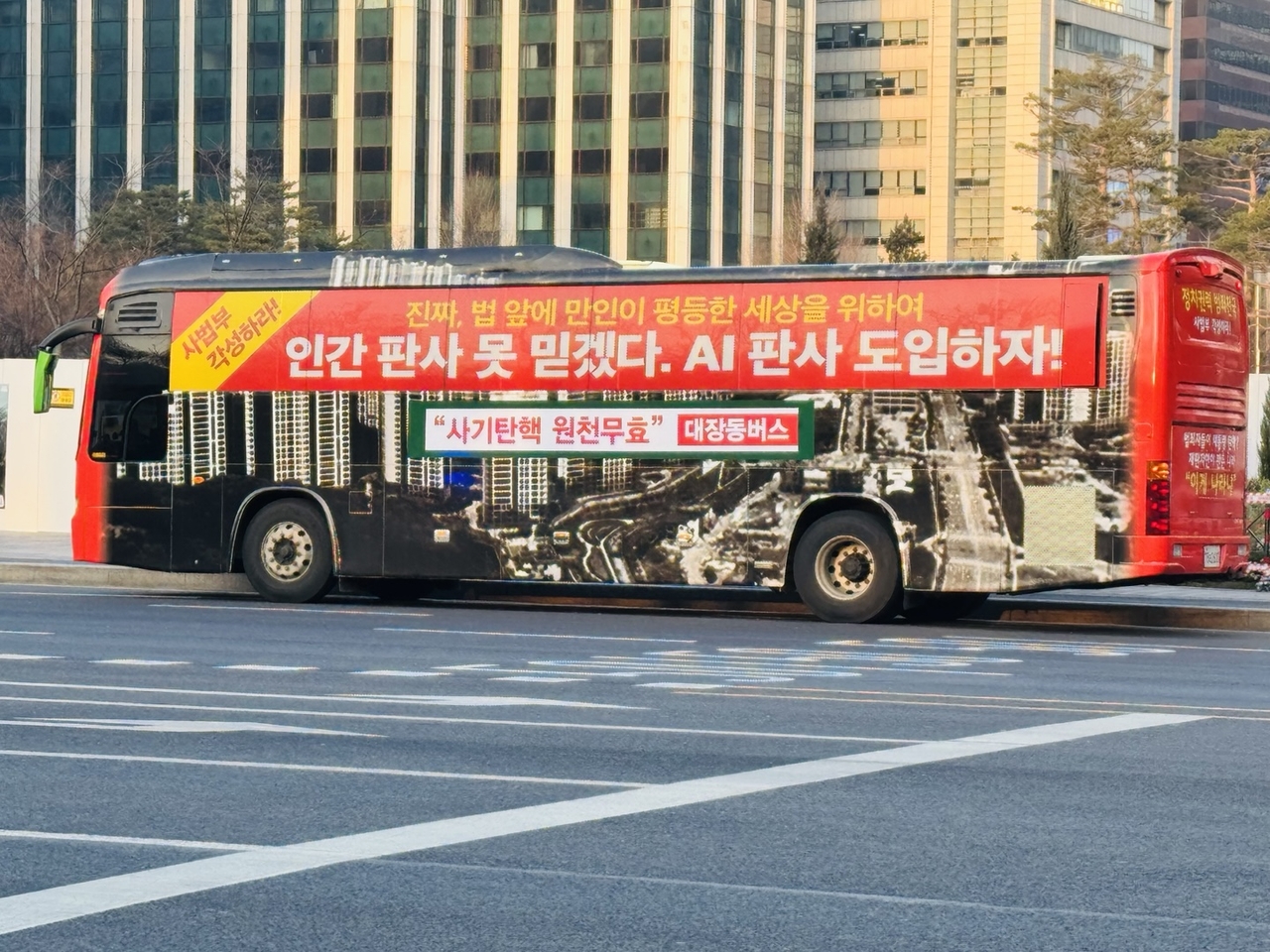 A bus displaying the message "We can't trust human judges. Let's introduce AI judges!" passes in front of City Hall on Saturday. (Sanjay Kumar/The Korea Herald)