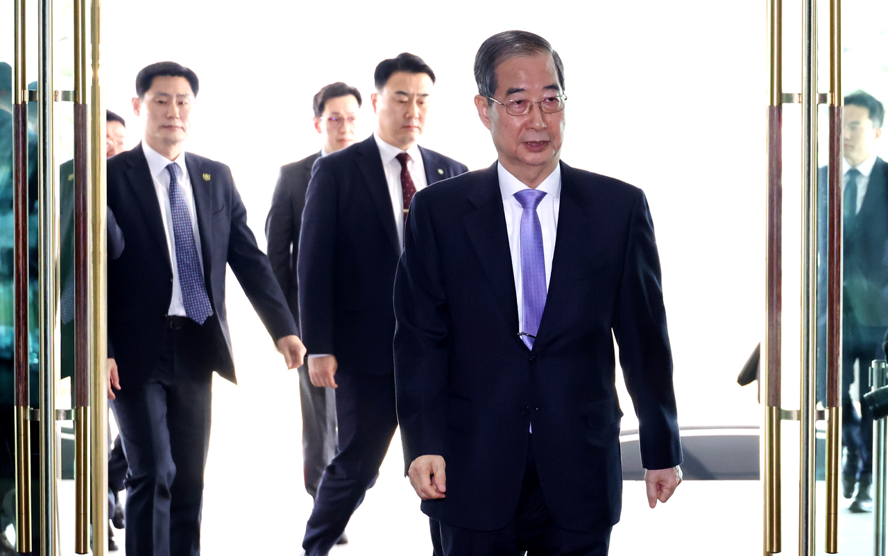 Acting President Han Duck-soo enters the government complex in Seoul after the Constitutional Court dismissed his impeachment case on Monday. (Yonahp)
