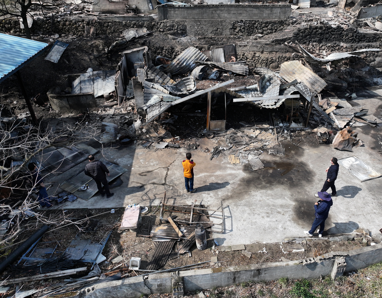 Residents inspect a burnt down house in Oegong Village, Sicheon-myeon, Sancheong-gun, South Gyeongsang Province, on Sunday. (Yonhap)