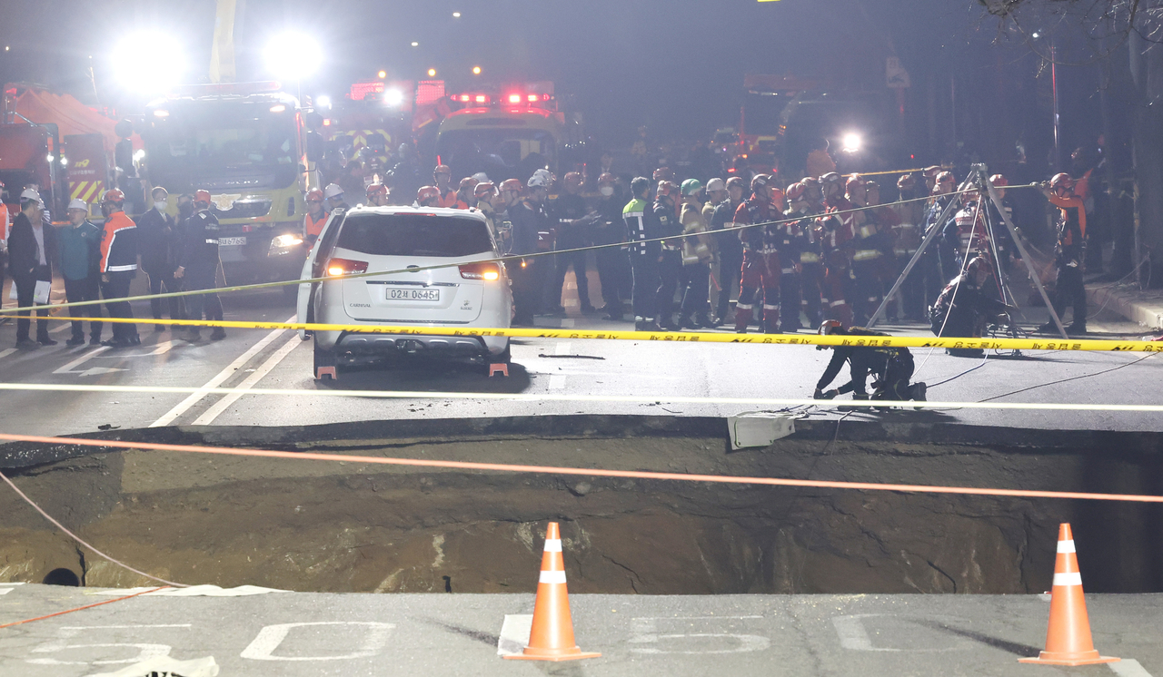 Firefighters prepare to conduct rescue operations at a sinkhole on a road in eastern Seoul on March 24, 2025. (Yonhap)