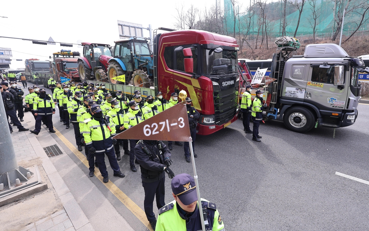 Tractors loaded on trucks by members of the Korean Peasants League are stopped by police near Namtaeryeong Pass in Seocho-gu, southern Seoul, on Tuesday, during a protest calling for suspended President Yoon Suk Yeol’s impeachment. (Yonhap)