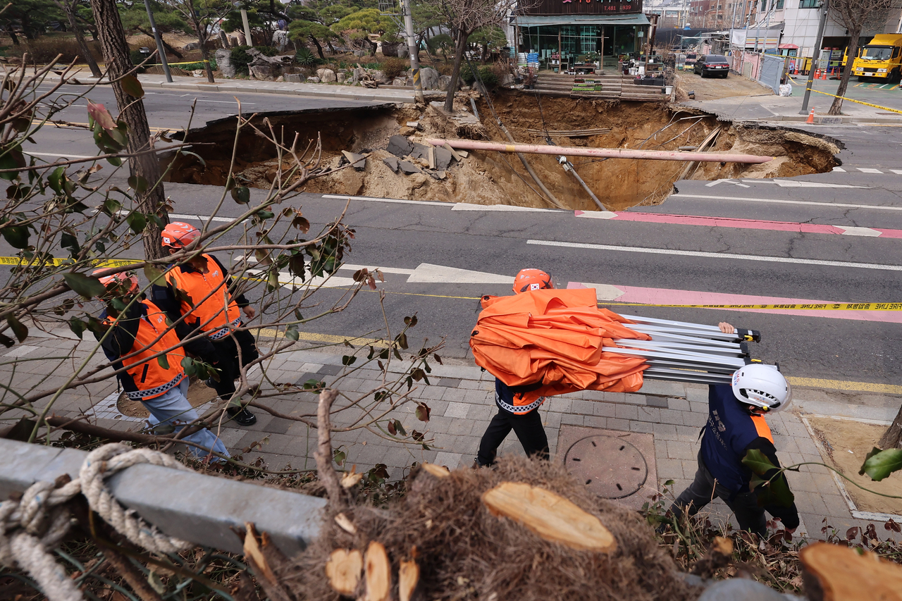 A 20-meter-wide and 18-meter-deep sinkhole, which injured one driver and swallowed up a motorcyclist on Monday, is seen formed at an intersection in Gangdong-gu, eastern Seoul. (Yonhap)