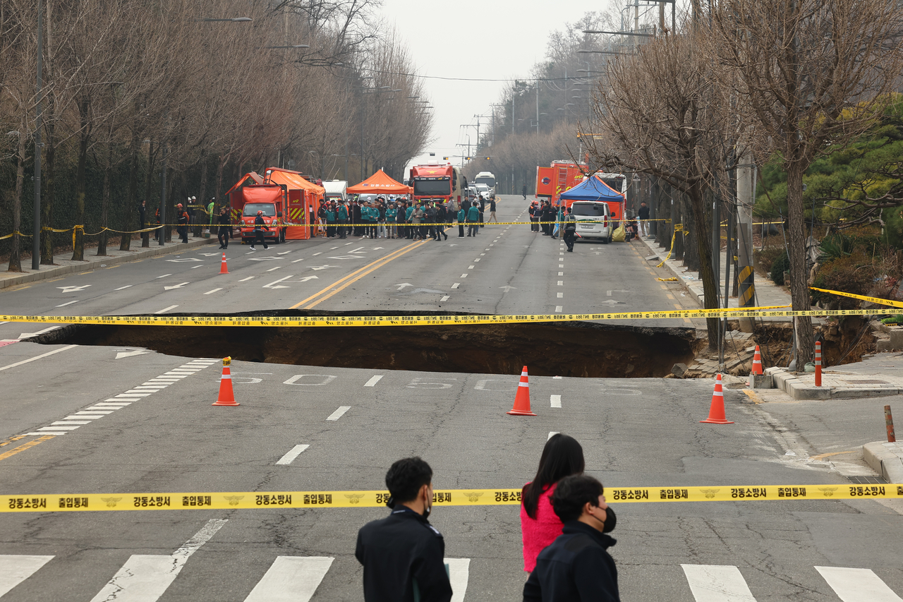 A 20-meter-wide and 18-meter-deep sinkhole, which injured one driver and swallowed up a motorcyclist on Monday, is seen formed at an intersection in Gangdong-gu, eastern Seoul. (Yonhap)