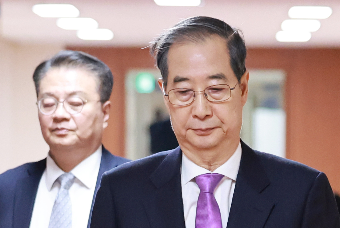Prime Minister and acting president Han Duck-soo (right) attends a Cabinet meeting held at the Government Complex Seoul on Tuesday. (Yonhap)