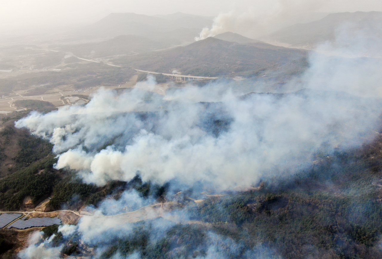 The wildfire in Uiseong County, North Gyeongsang Province, flames continues to spread on Tuesday, carried by strong winds into nearby hills in Anjeong-ri, Angye-myeon. (Yonhap)