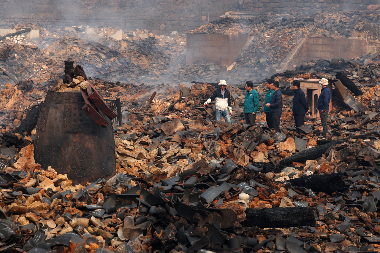 Government officials examine the remains of Gounsa Temple, incinerated by the wildfire that continued to spread for a fifth consecutive day in Uiseong-gun, North Gyeongsang Province, Wednesday. (Yonhap)