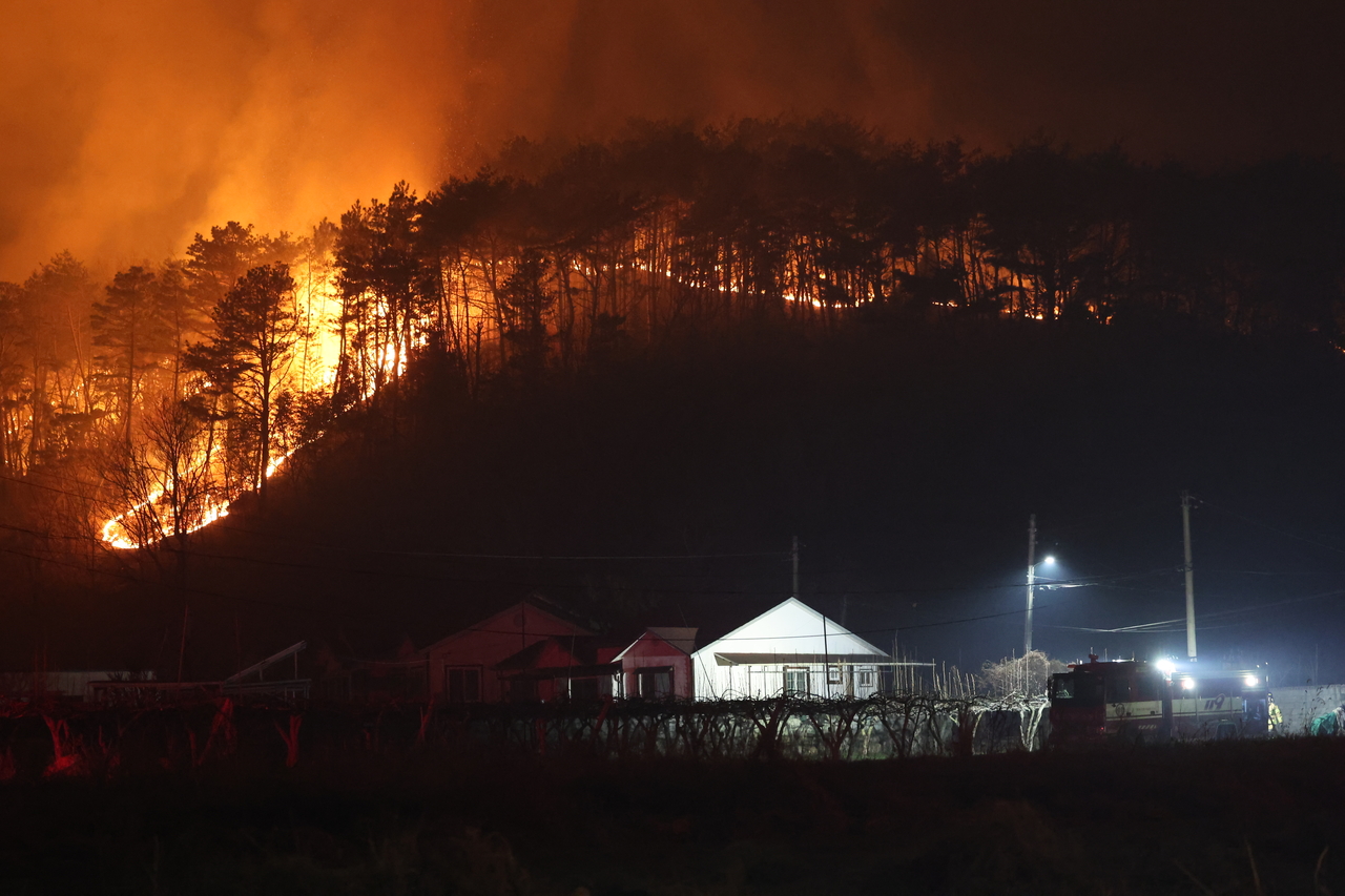 A wildfire spreads toward a residential area in Ulju County in Ulsan, late Tuesday night. (Yonhap)