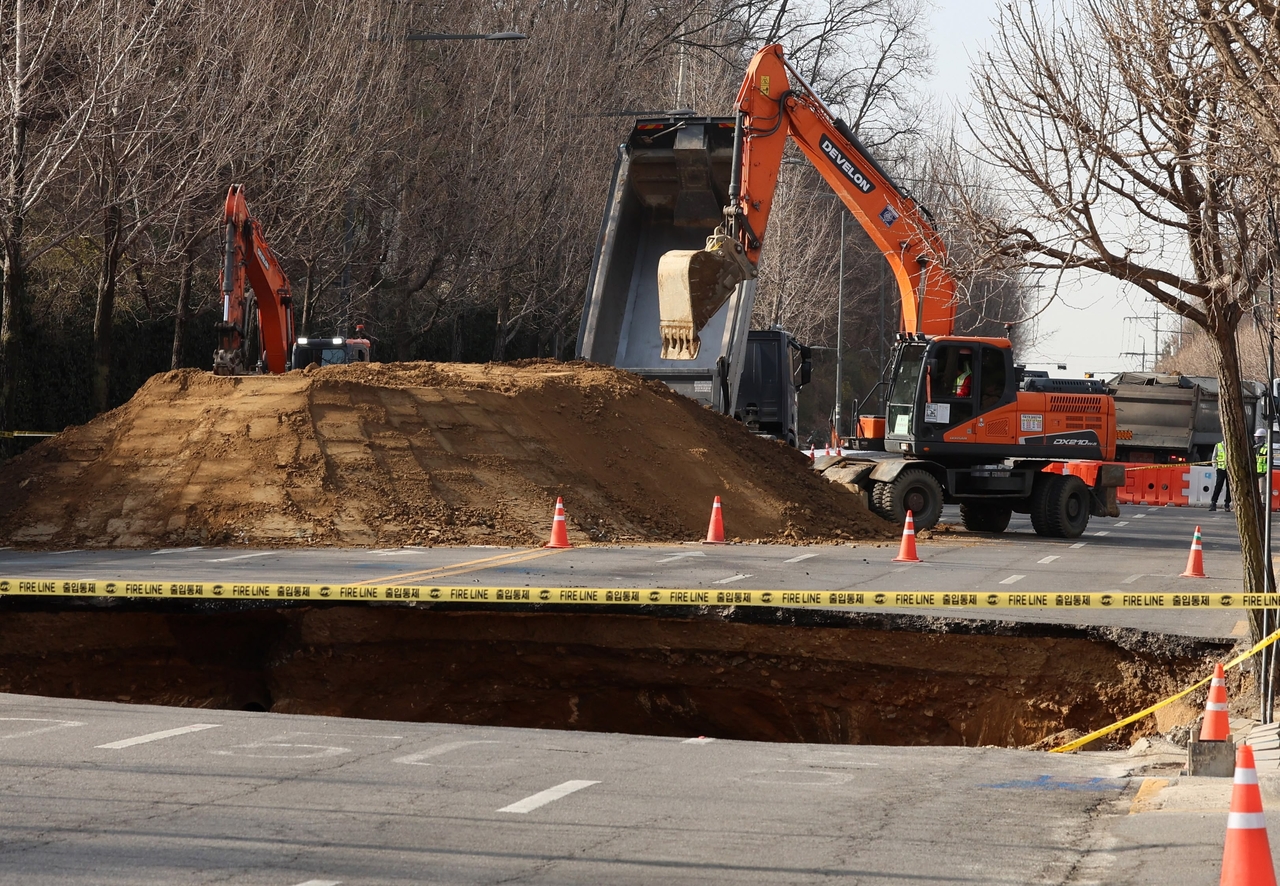 Construction crews begin recovery operations on Wednesday morning, two days after a deadly sinkhole tore through a major road in Gangdong-gu, Seoul. (Newsis)