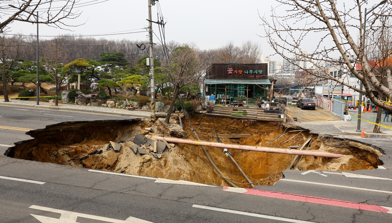 The aftermath of a major sinkhole near Myeongil Elementary School in eastern Seoul is seen on Tuesday, one day after the collapse tore through a main road in Gangdong-gu. (Newsis)