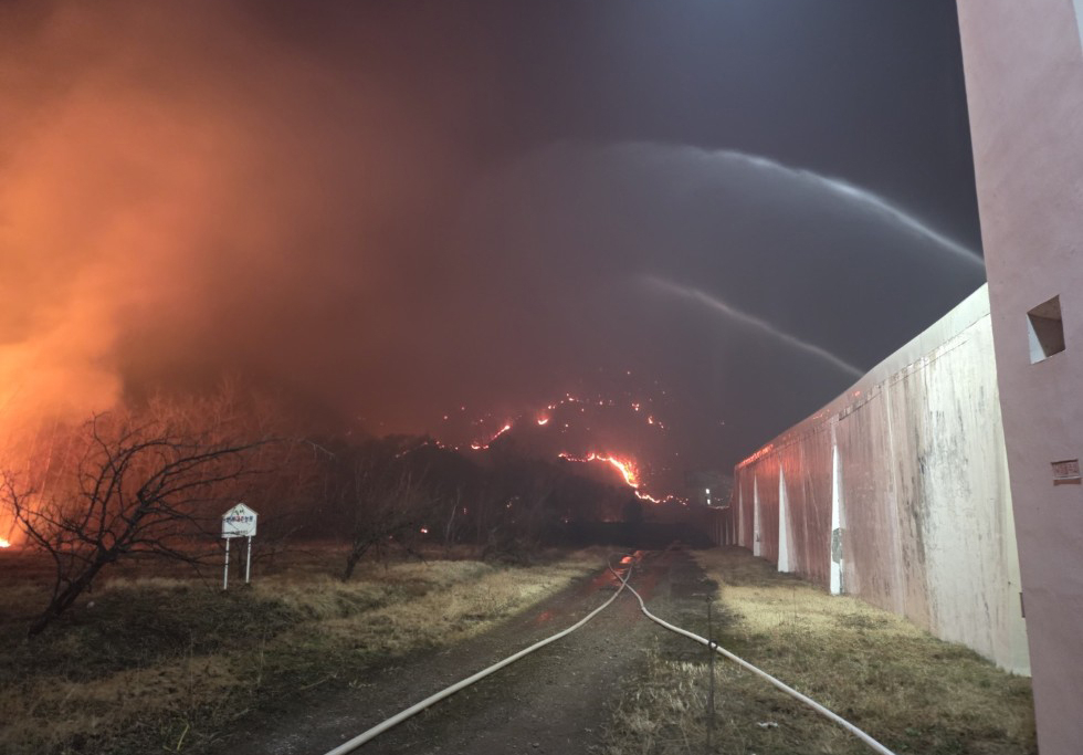 Staff at the Northern Correctional Institution of North Gyeongbuk Province are spraying water to prevent a forest fire from spreading to the prison area on Tuesday. (Yonhap)