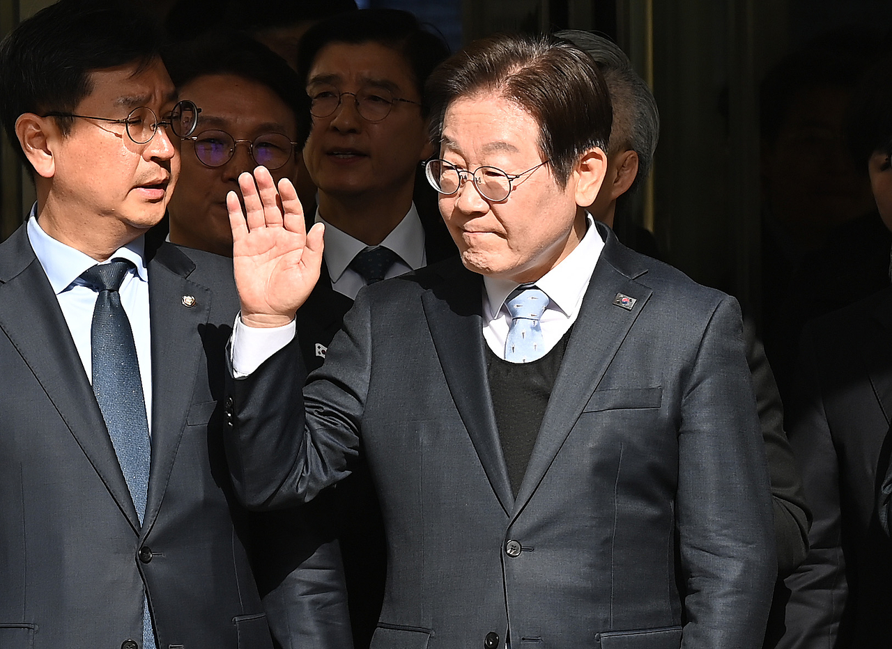 Democratic Party of Korea Chair Rep. Lee Jae-myung (right) walks out after an appellate court verdict cleared him of all charges of making false claims in violation of the Public Official Election Act on Wednesday, in Seoul. (Pool photo)