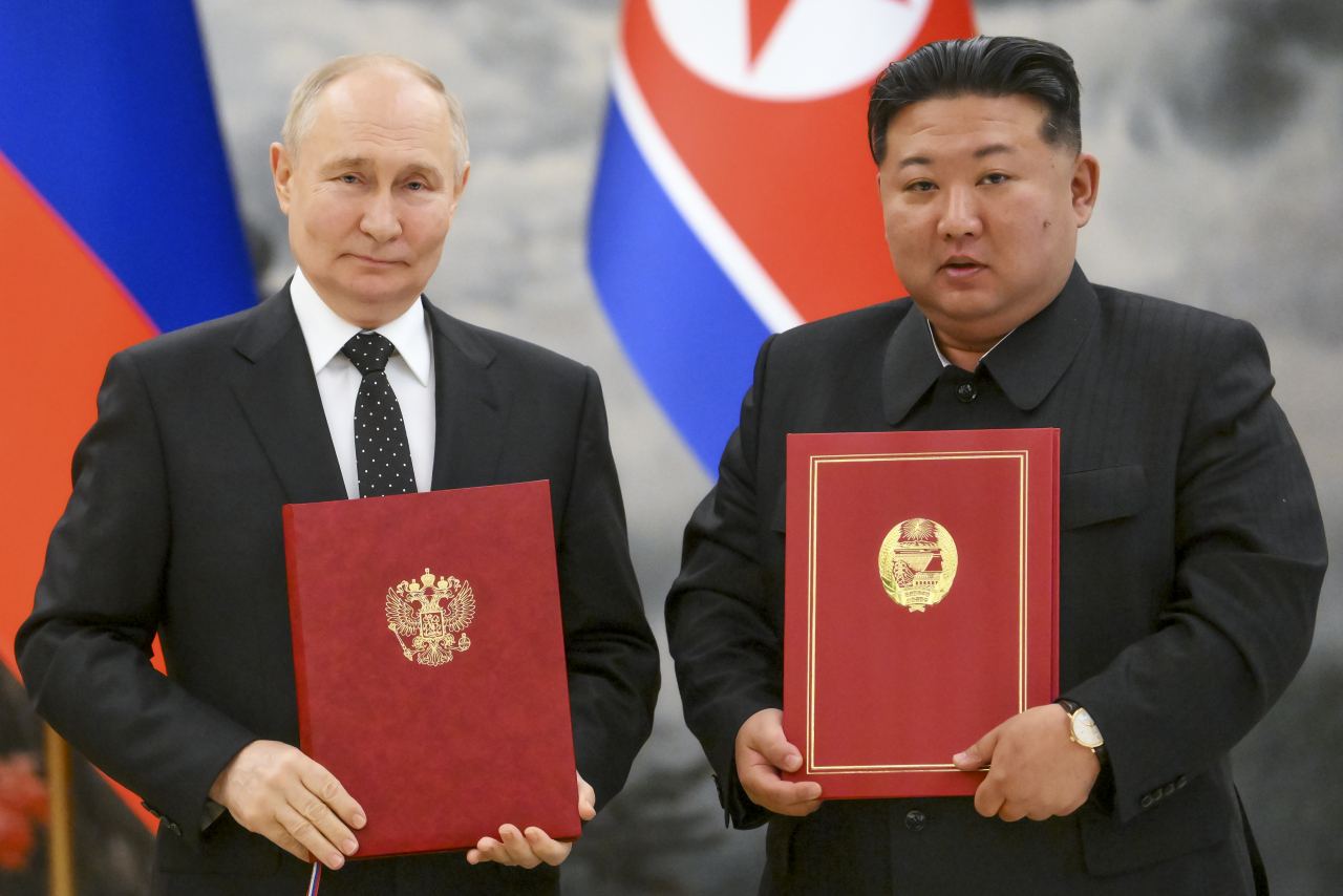 Russian President Vladimir Putin (left) and North Korean leader Kim Jong-un pose for a photo at a signing ceremony for their new partnership in Pyongyang, on June 19, 2024. (AP-Yonhap)