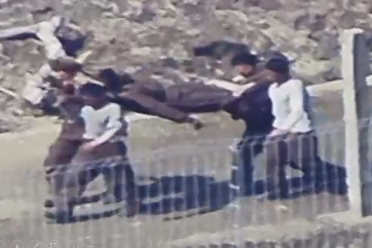 North Korean soldiers carry a fellow soldier apparently injured in a mine explosion at a construction site near the inter-Korean border, in an undated photo released by the South Korean military on Thursday. (Joint Chiefs of Staff)